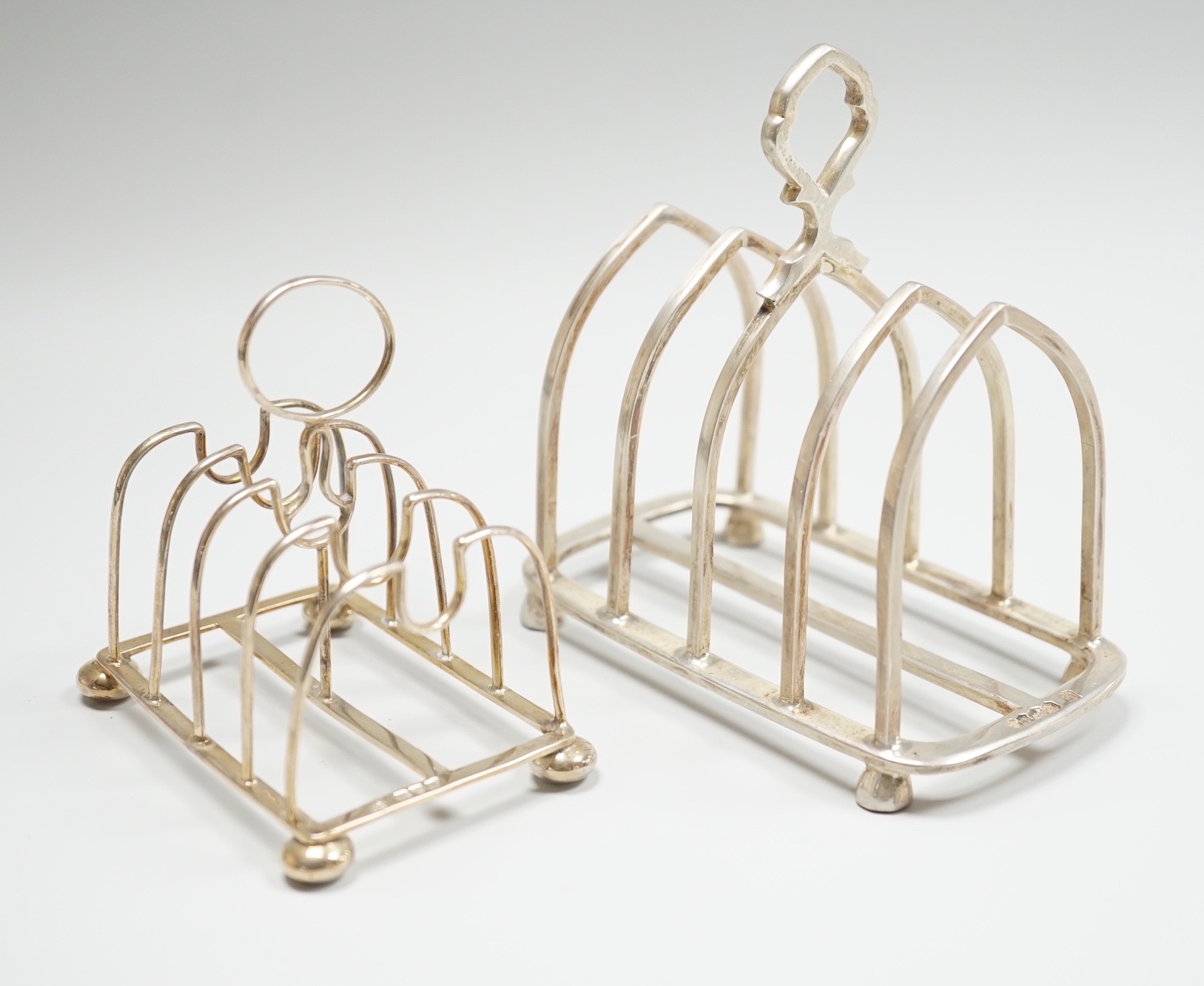 A small Edwardian silver five bar toast rack, Nathan & Hayes, Chester, 1908, 83mm and a later larger silver toast rack, 7.5oz.